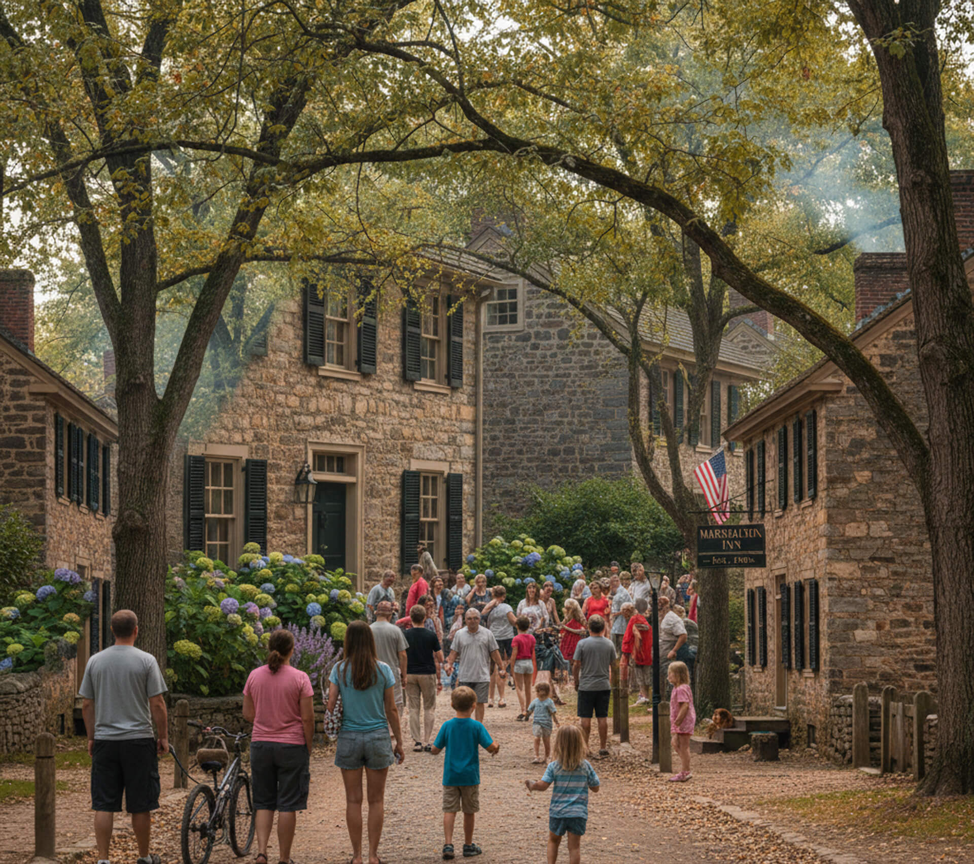 Crowd of families and children gathering in a historic village setting near the Marshalton Inn, surrounded by stone buildings and blooming hydrangeas, reflecting a community-oriented atmosphere.