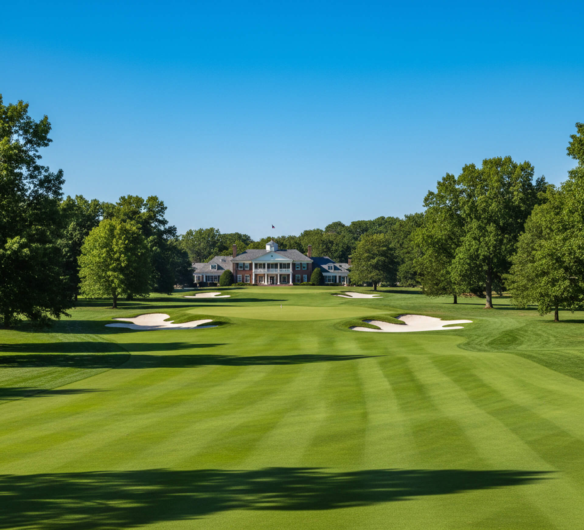 Lush green golf course with manicured fairways, sand traps, and a grand clubhouse in the background, representing family-friendly leisure activities near M.Y. Family Dentistry in Newtown Square, PA.