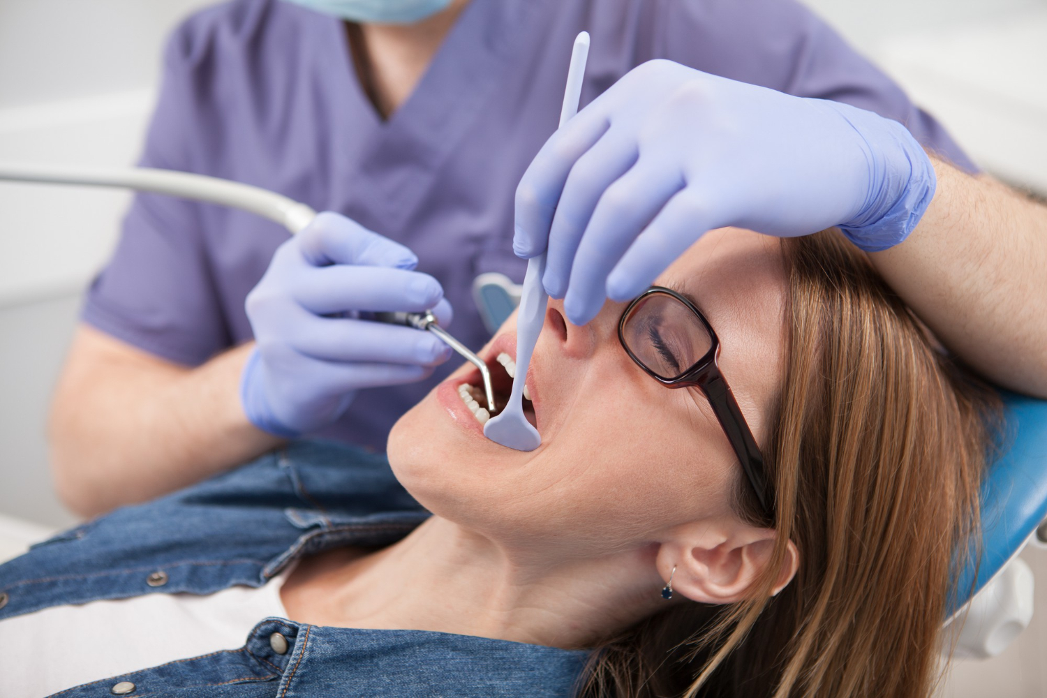 Dental bonding in West Chester procedure showing a dentist repairing a tooth with composite resin.