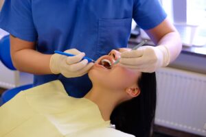 Dental professional treating a patient with oral examination tools